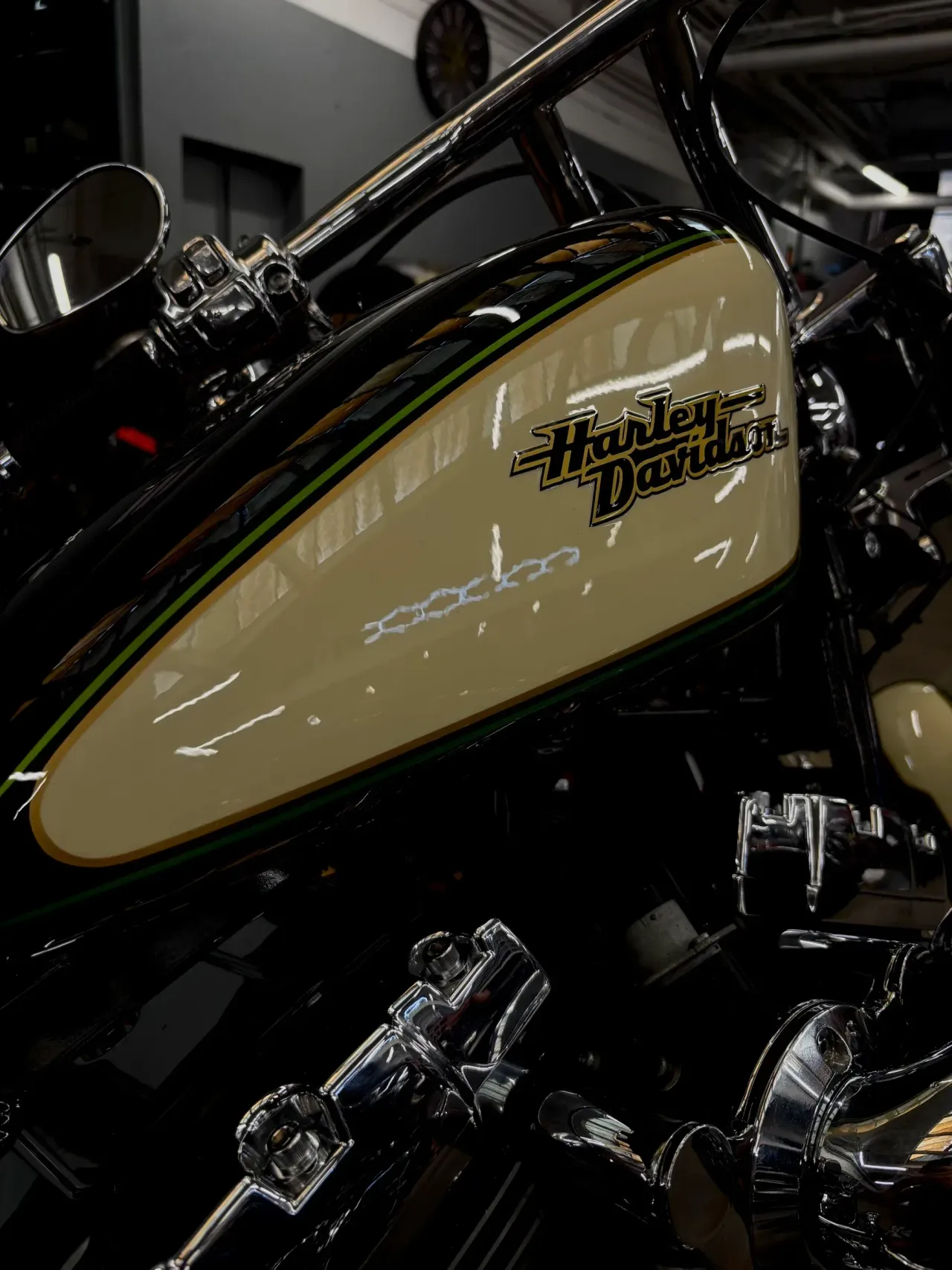 Szerokie ujęcie plakietki zbiornika Harley Davidson na tle warsztatu